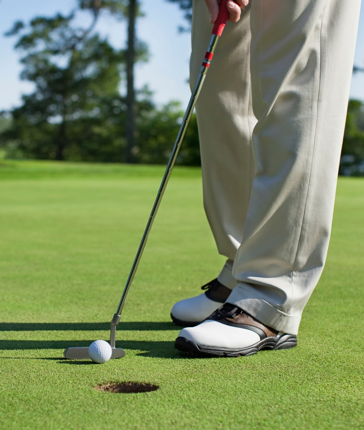 Golfer mid-swing wearing Surefoot custom golf orthotics