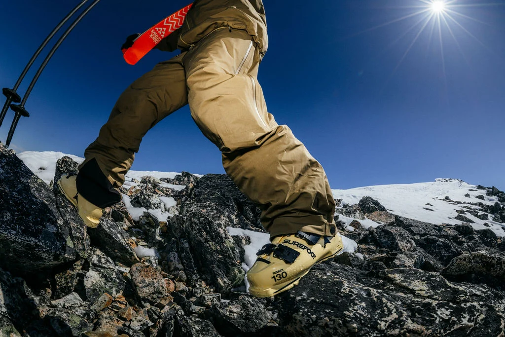 Yellow Surefoot ski boots on a rocky ridge under the sun